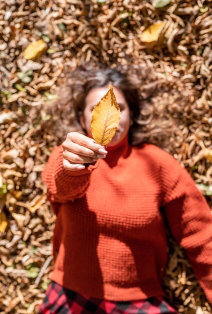Środkowa sekcja osoby trzymającej suche liście jesienią