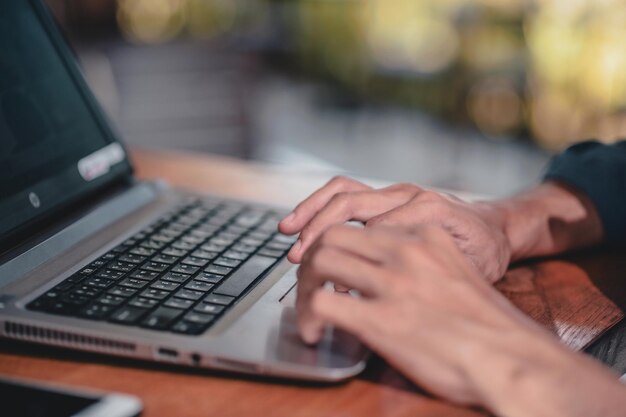 Zdjęcie Środkowa sekcja osoby używającej laptopa na stole