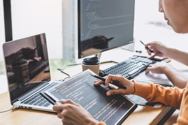 Środkowa sekcja programistów komputerowych używających laptopa na biurku