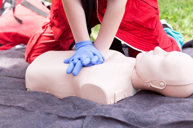 Środkowa sekcja ratownika wykonującego CPR na manekinie