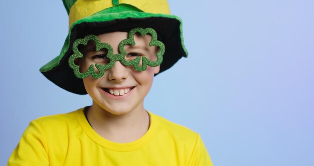 Zdjęcie st patrick's day banner portret radosnego dziecka w okularach w kształcie koniczyny