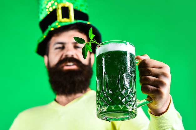 St patricks day z bliska portret szczęśliwy brodaty mężczyzna w koniczyna kapelusz krasnoludek w szklance piwa