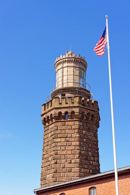 Stacja świetlna i amerykańska flaga w Sandy Hook. Nazywa się Navesink Twin Lights. Sandy Hook znajduje się w Highlands w hrabstwie Monmouth w New Jersey, USA