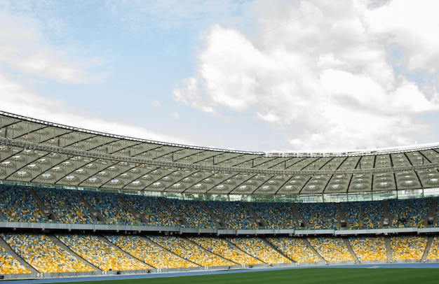 Stadion piłkarski wewnątrz widoku puste boisko do piłki nożnej stoi tłum fanów na dachu na tle nieba