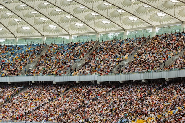 Zdjęcie stadion piłkarski wewnątrz widoku puste boisko do piłki nożnej stoi tłum fanów na dachu na tle nieba