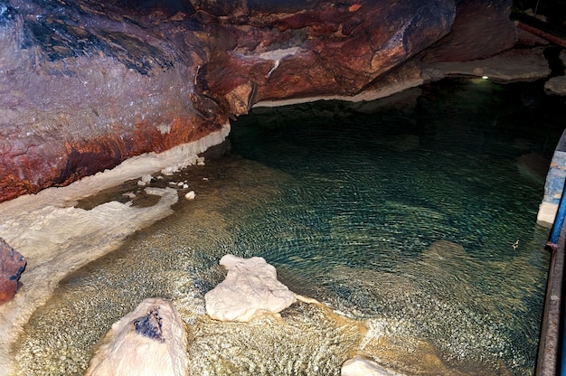 Stalaktytowy stalagmit na ścianach jaskini Jaskiniowe jezioro Szablon do projektowania