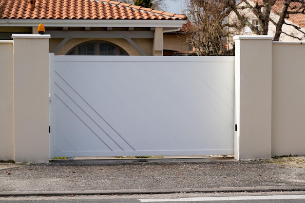 Stalowy nowoczesny portal aluminiowy z białą bramą z projektem skrzydeł podmiejskiego domu
