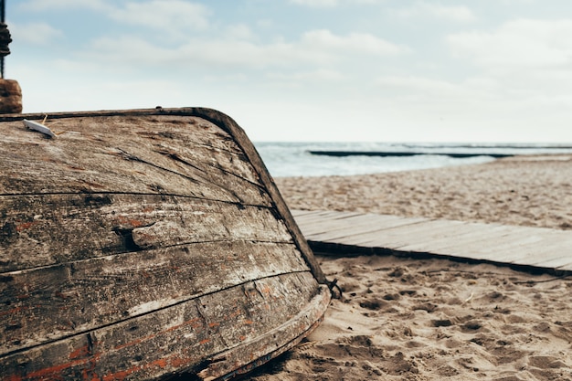 Stara drewniana łódź do góry nogami na plaży