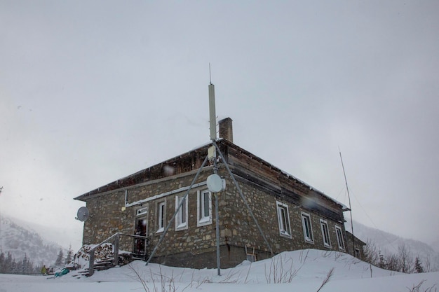 Stara górska chata pokryta śniegiem Obserwatorium meteorologiczne na górze Pozhyzhevska Czarnohora