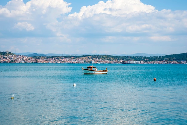 Stara i mała łódź rybacka w tle tureckiego miasta w letni i słoneczny dzień