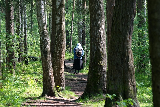 Stara kobieta idzie leśną ścieżką Region moskiewski Rosja