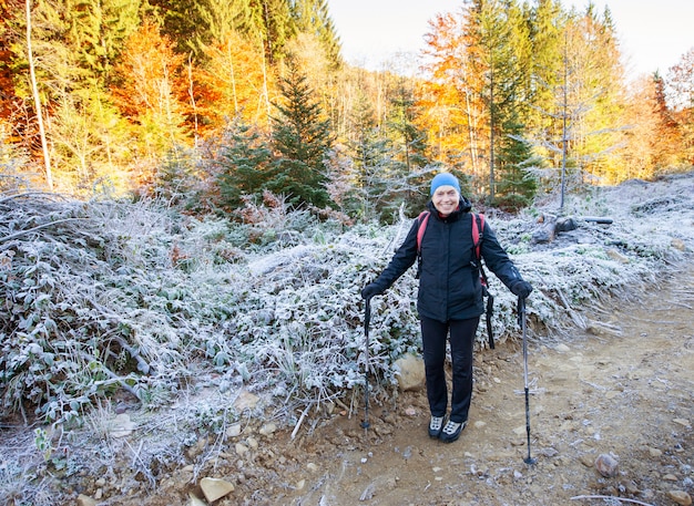 Zdjęcie stara kobieta wycieczkowicza odprowadzenie na halnej drodze z plecakiem