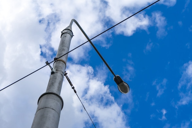 Zdjęcie stara latarnia uliczna z wieloma podłączonymi kablami, na białym tle na szarym niebie. skopiuj miejsce.