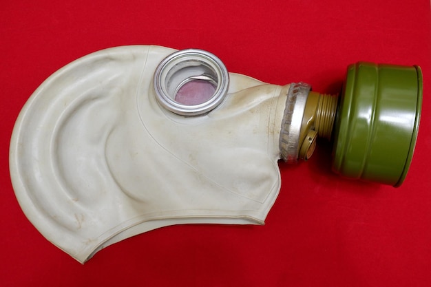 Zdjęcie stara maska gazowa z bliska na czerwonym tle