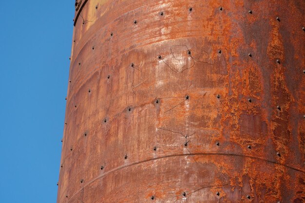 Stara metalowa zardzewiała wieża ciśnień Stara technologia produkcji suszenie w kompleksie rolno-przemysłowym Czerwony silos na tle nieba Konstrukcja metalowa