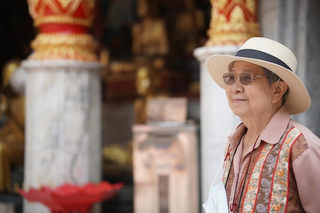 Stara starsza kobieta, starsza kobieta podróżująca, podróżująca w azjatyckiej świątyni. rekreacyjny styl życia seniora