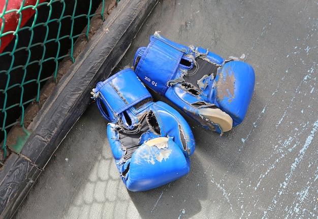 Stare błękitne bokserskie rękawiczki kłaść na podłoga