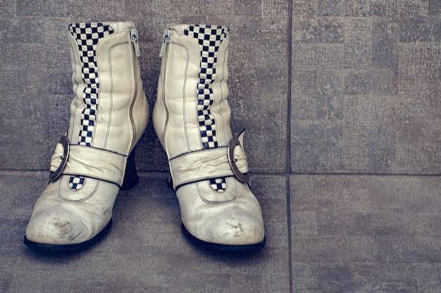 Stare buty z klamrami na brudnym betonowym tle