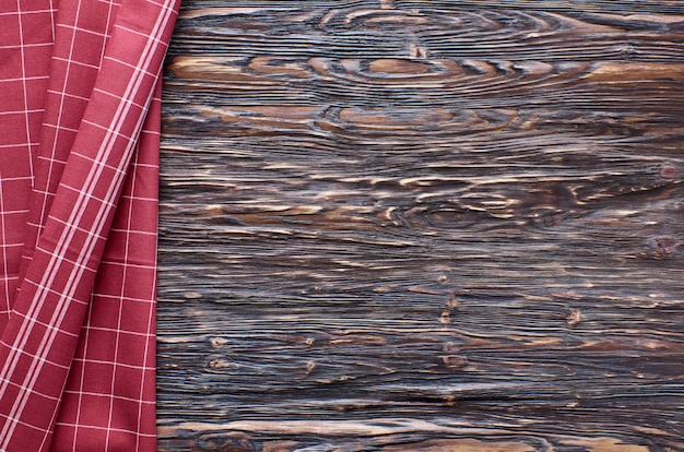 Stare ciemne drewniane tła. Drewniany stół z czerwonym ręcznikiem kuchennym