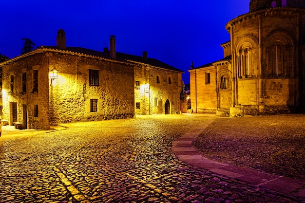 Stare domy z kamienia miasta z kościołem w nocy. Santillana del Mar, Santander.