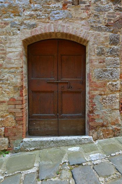 Stare drewniane drzwi w ścianie z cegły