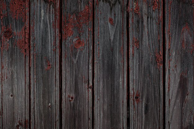 Zdjęcie stare naturalne wyblakłe drewniane deski z pękniętym czerwonym tłem farby