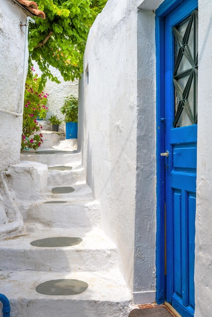 Stare niebieskie drzwi na wąskiej uliczce w dzielnicy Anafiotika Plaka Ateny Grecja Plaka jest atrakcją turystyczną Aten Zabytkowa aleja ze schodami