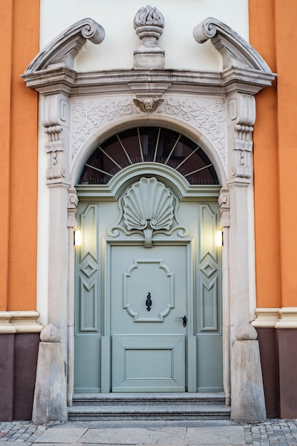 Stare niebieskie drzwi z łukiem w stylu barokowym
