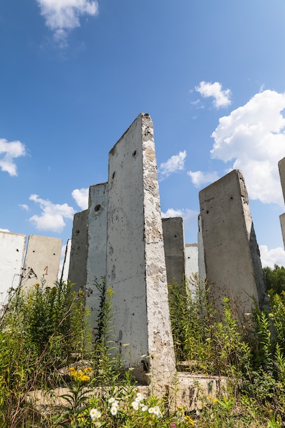 Stare płyty betonowe stojące w polu. Stary niedokończony budynek