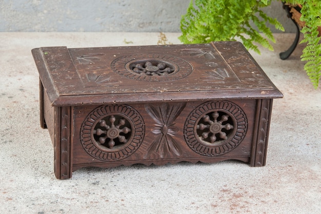 Stare rzeźbione drewniane pudełko na betonowym tle. Skopiuj miejsce na tekst.