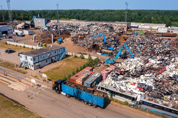 Stare, uszkodzone samochody na złomowisku czekające na recykling