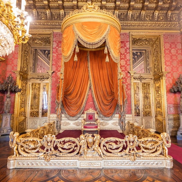 Stare wnętrze sali tronowej z krzesłem w luksusowym pałacu Czerwony i złoty antyczny styl barokowy