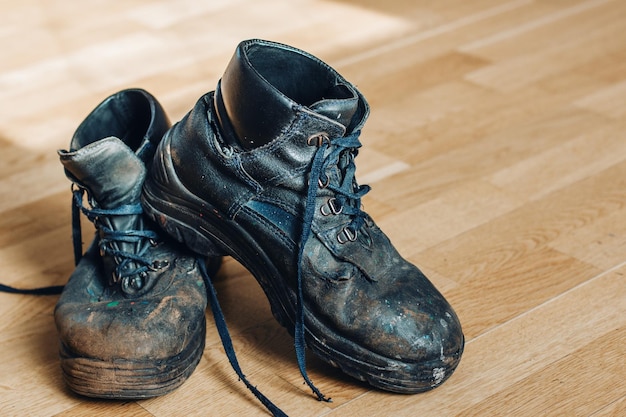 Stare zużyte buty robotnika Buty, które wymagają naprawy lub wymiany