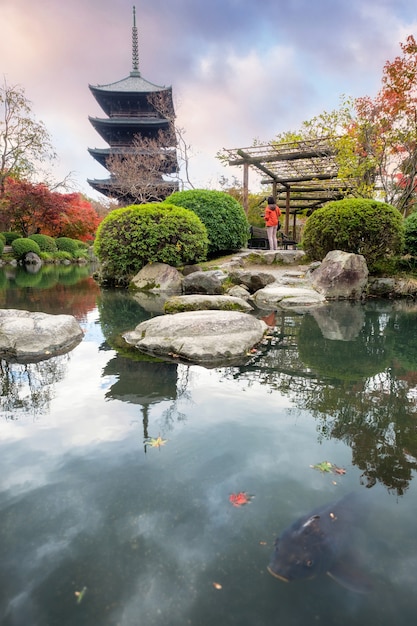 Starożytna drewniana pagoda z rybami w jesiennym ogrodzie w świątyni Toji, Kioto, Japonia