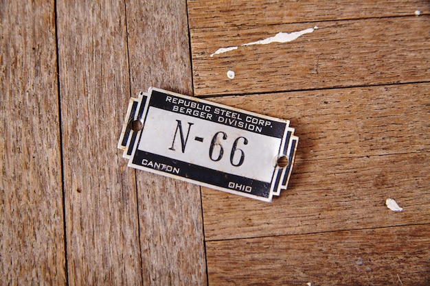 Zdjęcie starożytna przemysłowa tabliczka identyfikacyjna ze stali n66 na wytrzymałym drewnie