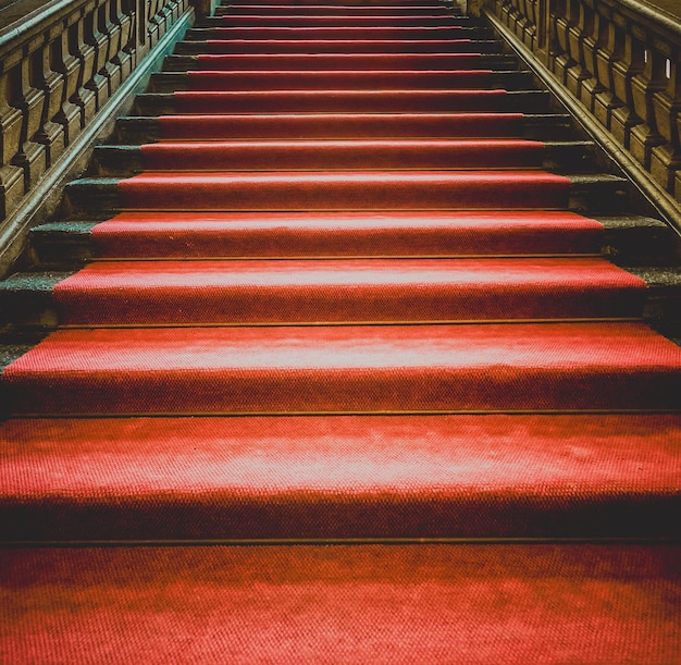 Starożytne ciemne schody z czerwonym dywanem
