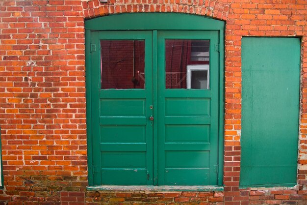 Starożytne zielone drzwi w murze z czerwonych cegieł w mieście Michigan