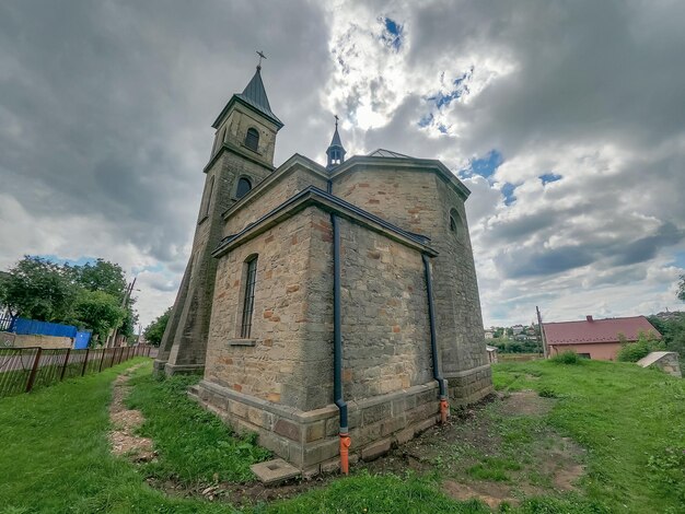 Zdjęcie starożytny kamienny kościół na tle pochmurnego nieba ciekawa perspektywa