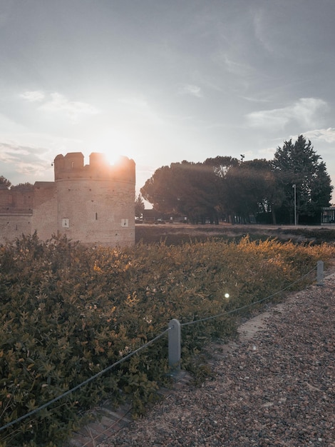 Starożytny średniowieczny zamek z fosą z przodu o zachodzie słońca ze słońcem padającym na wieżę w Hiszpanii