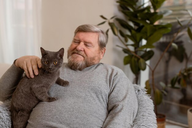 Starsi ludzie opiekują się kotami i cieszą się nimi w domu
