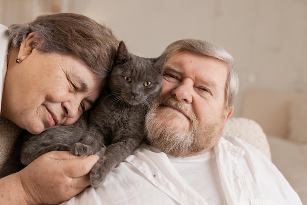 Starsi ludzie opiekują się kotami i cieszą się nimi w domu