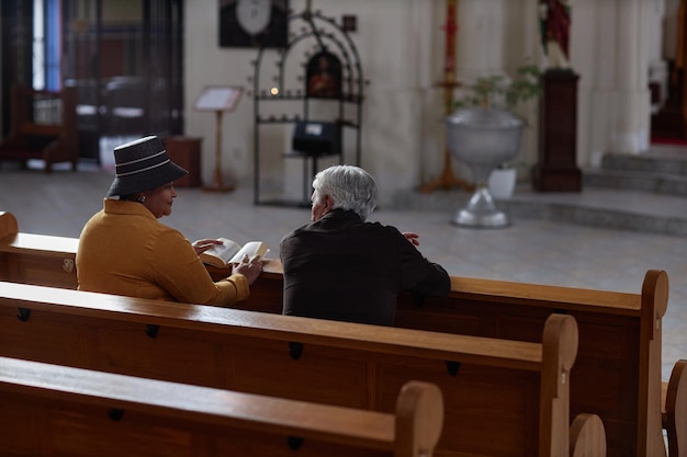 Starsi ludzie siedzący w kościele podczas posługi
