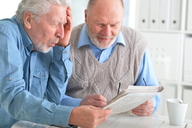 Starsi mężczyźni czytają gazetę