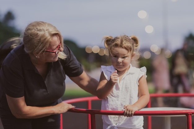 Starsza babcia bawi się z wnukiem w parku o zachodzie słońca selektywnym ostrością