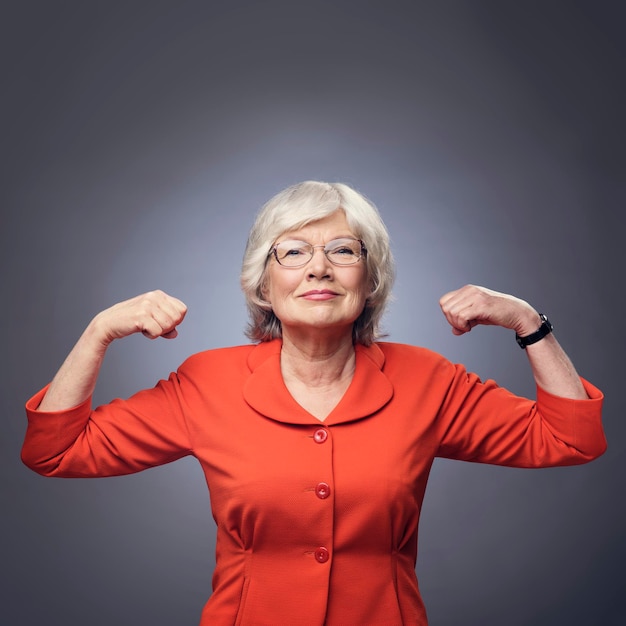 Starsza dama pokazująca mięśnie