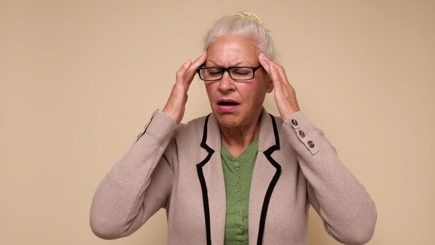 Zdjęcie starsza europejka cierpi na ból głowy i trzyma palce na skroniach
