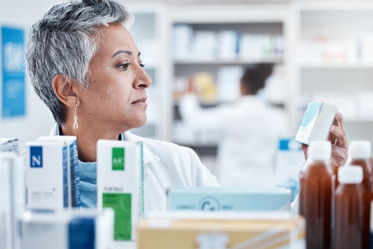 Zdjęcie starsza farmaceutka i sprawdź z lekiem pudełkowym lub pigułkami na półce w sklepie dla usług opieki zdrowotnej starszy ekspert farmaceutyczny w sprzedaży detalicznej i produkt medyczny dla makiety zdrowia i dobrego samopoczucia