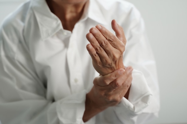 Starsza kobieta cierpi na ból spowodowany reumatoidalnym zapaleniem stawów