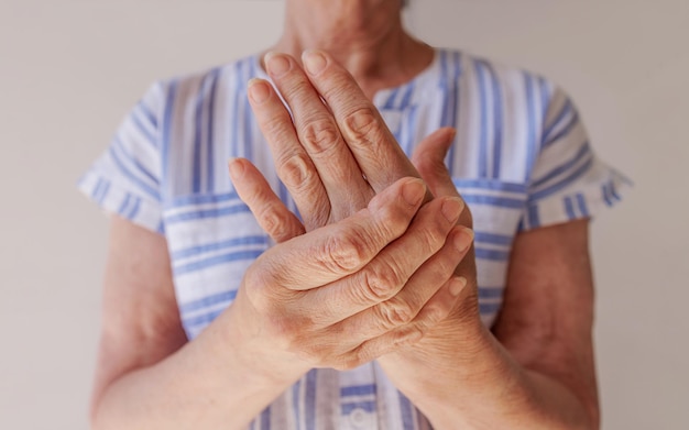Zdjęcie starsza kobieta cierpiąca na ból w dłoni masuje zbliżenie nadgarstka