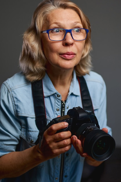 Starsza kobieta fotograf robi zdjęcia aparatem dslr